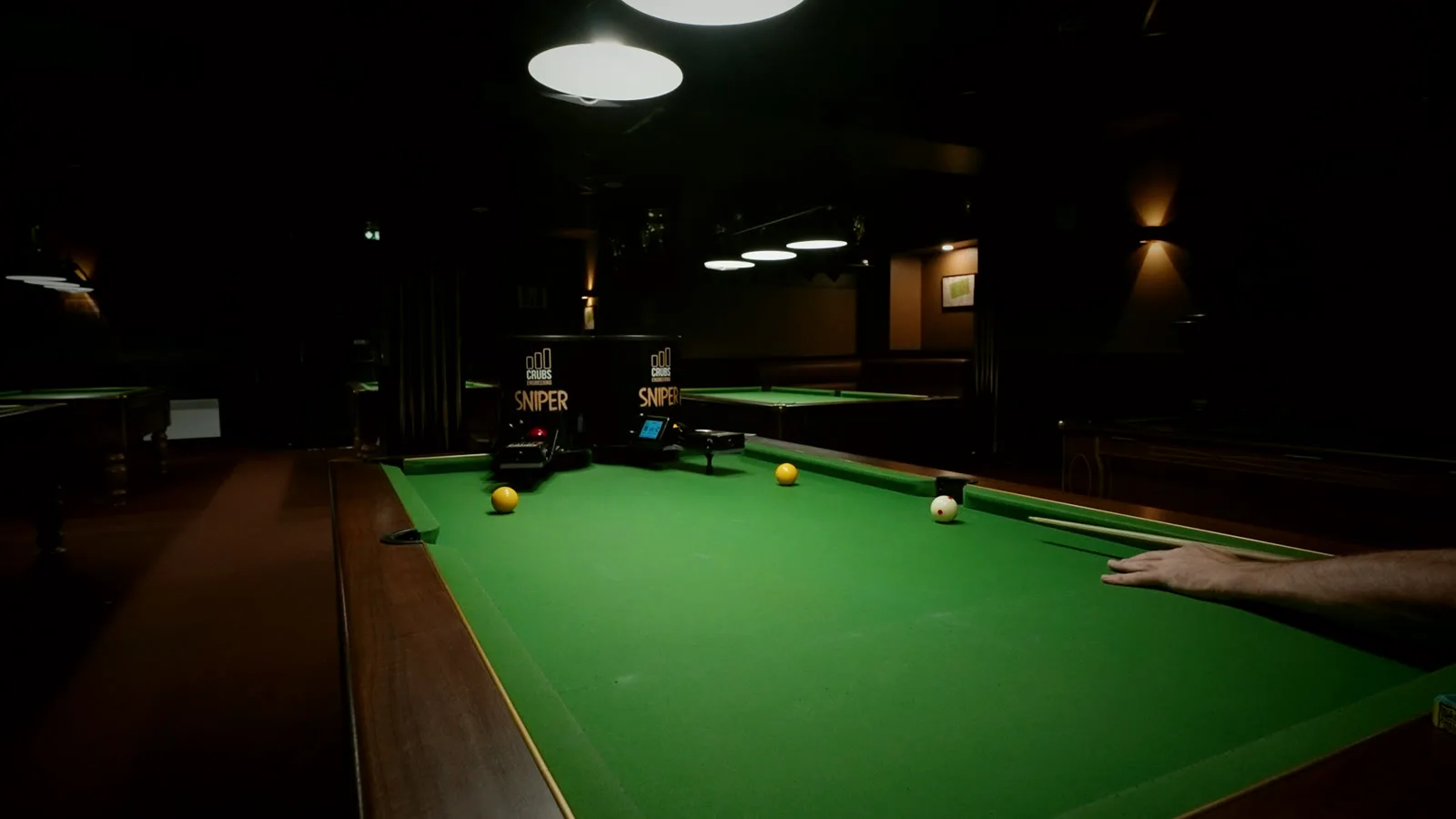 Salle de billard équipée de Sniper, plusieurs tables sous les suspensions.