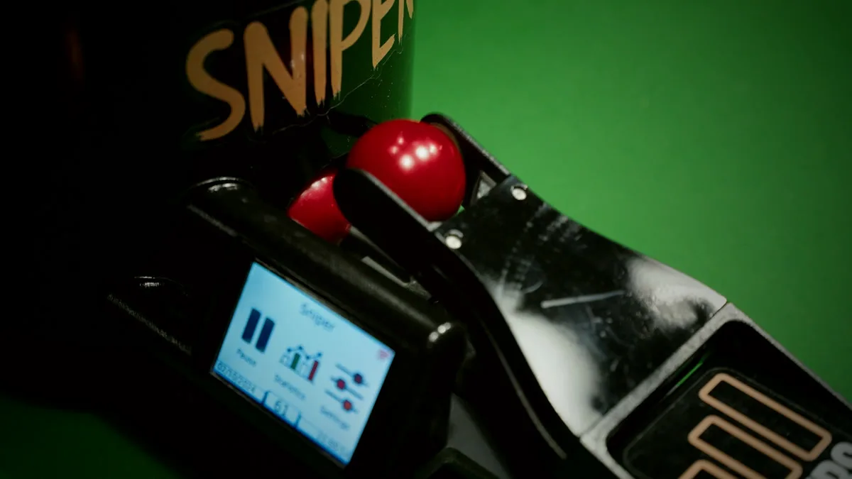 Écran de commande du Sniper, posé sur la table, billes rouges sur la rampe.